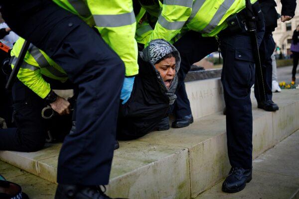 Police officers detain a protester during an anti-CCP virus lockdown demonstration outside the Houses of Parliament in Westminster, central London, on Jan. 6, 2021. (Tolga Akmen/AFP via Getty Images)