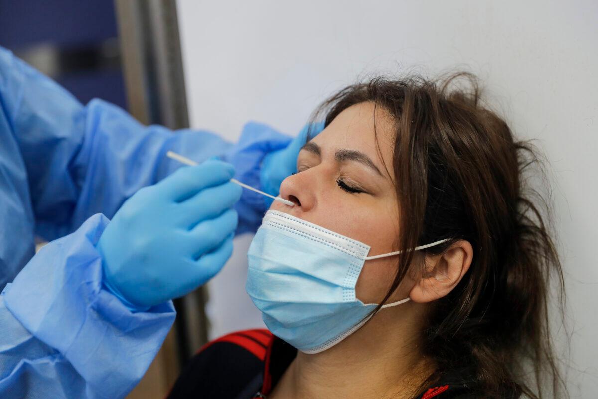 A health care worker administers a PCR test on a woman in the intensive care unit of the Rafik Hariri University Hospital in Beirut, on Jan. 5, 2021. (Joseph Eid/AFP via Getty Images)