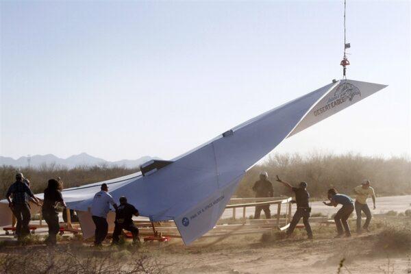 Thompson designed and built a 45-foot-long paper airplane with a wingspan of 24 feet, here being lifted up with a helicopter for its flight for the Pima Air & Space Museum's Great Paper Airplane Project, on March 21, 2012. During the flight, it reached a top speed of 98 miles per hour and an altitude of 2,703 feet; it was in free flight for 0.93 miles. The project aimed to excite kids about aviation and engineering, and the design was based on a 12-year-old Tucson student's design. (Courtesy of Sage Cheshire)