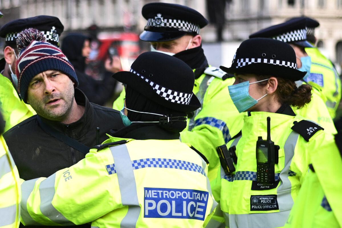 An anti-lockdown protester is held by police officers in Parliament Square outside the House of Commons in London on Jan. 6, 2021. (Leon Neal/Getty Images)