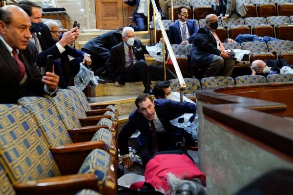 People shelter in the House gallery as a group of rioters try to break into the House Chamber at the U.S. Capitol in Washington on Jan. 6, 2021. (Andrew Harnik/AP Photo)