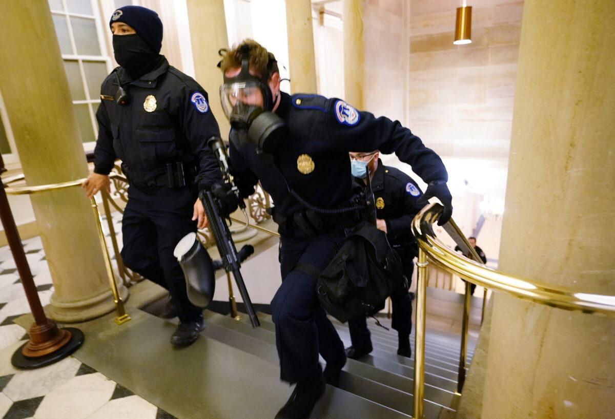 U.S. Capitol police officers take positions as protestors enter the Capitol building during a joint session of Congress in Washington on Jan. 6, 2021. (Kevin Dietsch/Pool via Reuters)