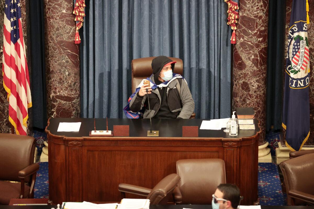 A protester sits in the Senate Chamber in Washington on Jan. 6, 2021. (Win McNamee/Getty Images)