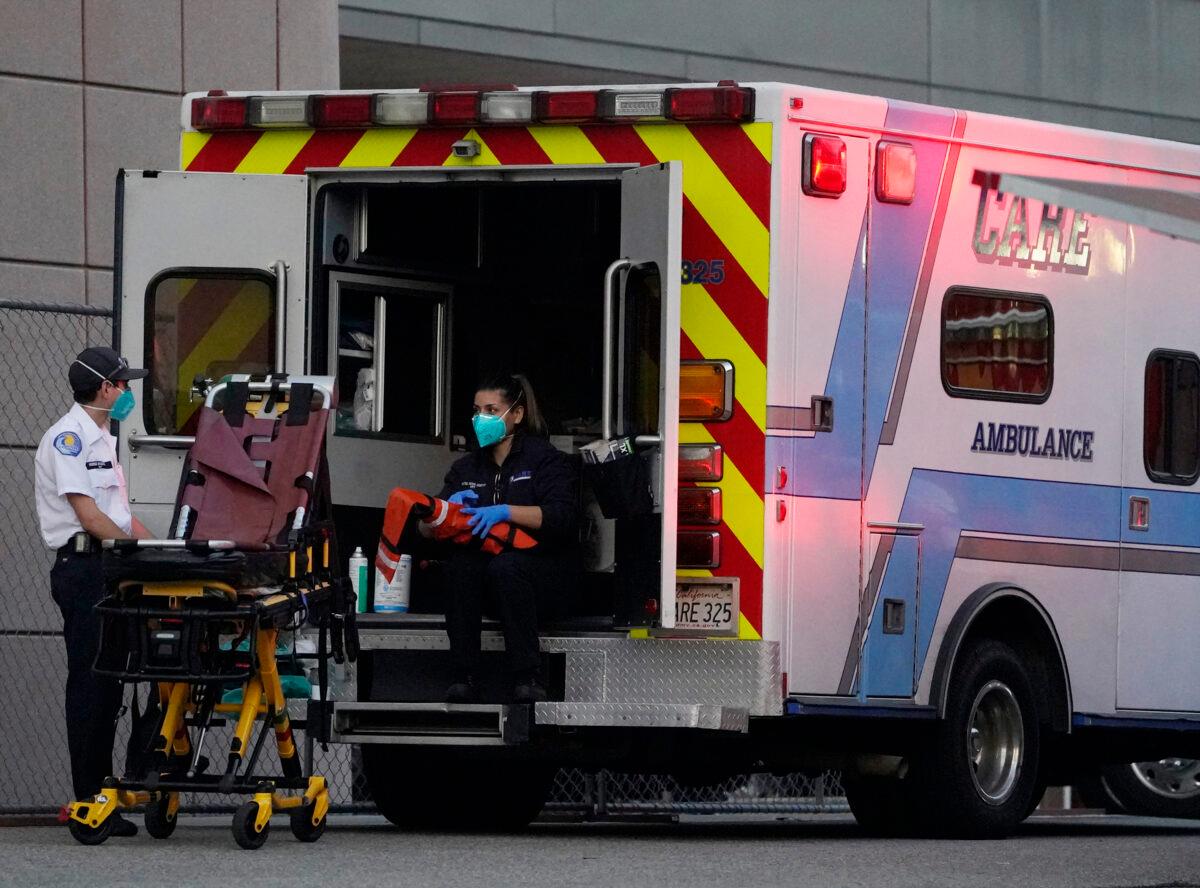Emergency medical technicians sanitize their ambulance stretcher after transporting a patient at Los Angeles County + USC Medical Center in Los Angeles on Jan. 5, 2021. (Damian Dovarganes/AP Photo)
