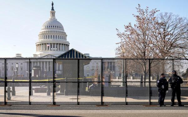 Capitol police officers stand outside of fencing that was installed around the exterior of the Capitol grounds, in Washington on Jan. 7, 2021. (AP Photo/John Minchillo)