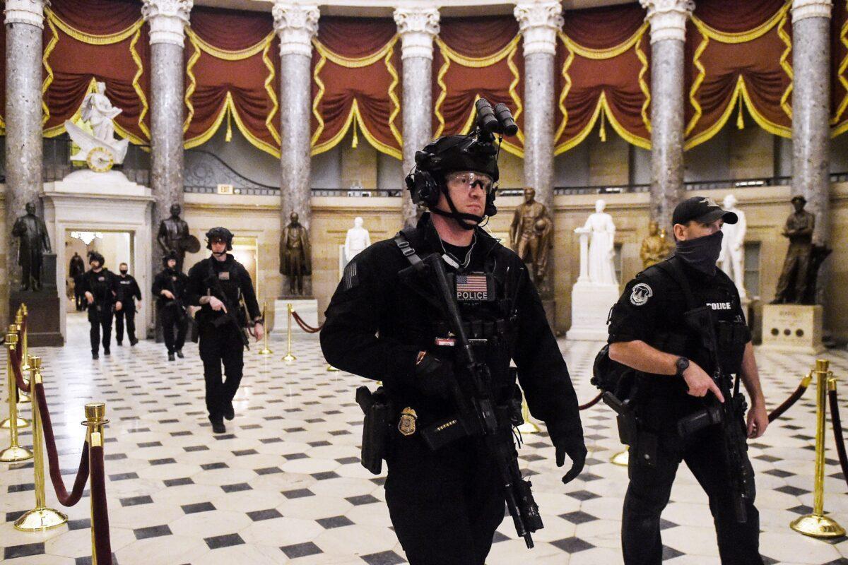 Members of the SWAT team patrol and secure the Statuary Hall before Vice President Mike Pence makes his way into the House Chamber, at the U.S. Capitol in Washington on Jan. 7, 2021. (Olivier Douliery/AFP via Getty Images)