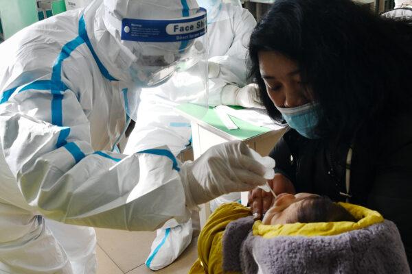 A medical worker takes a swab sample from an infant for a COVID-19 test in Shijiazhuang city, Hebei Province, China, on Jan. 7, 2021. (STR/CNS/AFP via Getty Images)