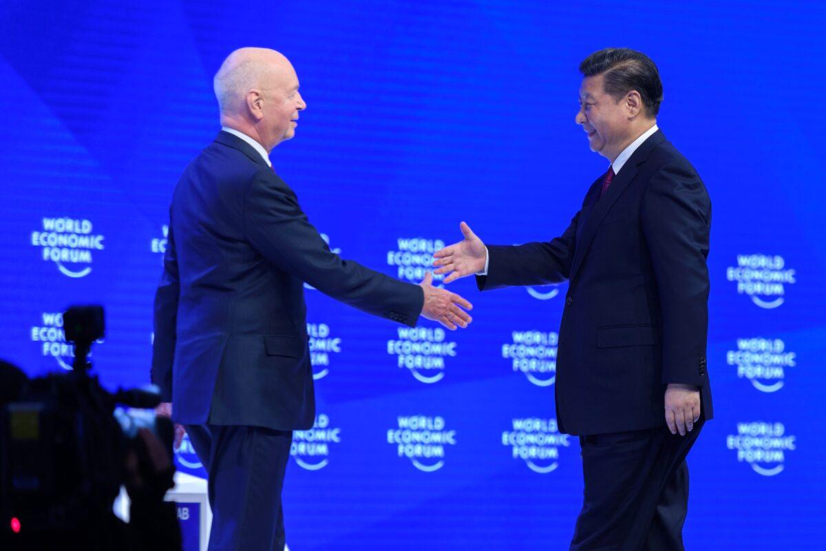 China's leader Xi Jinping (R) shakes hands with founder and executive chairperson of the World Economic Forum, Klaus Schwab prior to delivering a speech during the first day of the WEF in Davos, Switzerland, on Jan. 17, 2017. (Fabrice Coffrini/AFP via Getty Images)