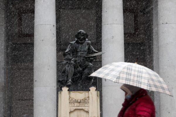 A woman walks past a statue of Spanish painter Diego Velazquez outside the Prado Museum during a snowfall in Madrid, Spain, on Jan. 7, 2021. (Susana Vera/Reuters File Photo)