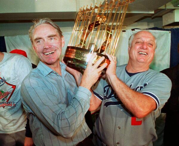 Los Angeles Dodgers manager Tommy Lasorda (R) and Fred Claire, Dodger Vice President, hoist the World Series trophy following their team's 5-2 win over the Oakland Athletics in Oakland, Calif., on Oct. 20, 1988. (AP Photo/File)