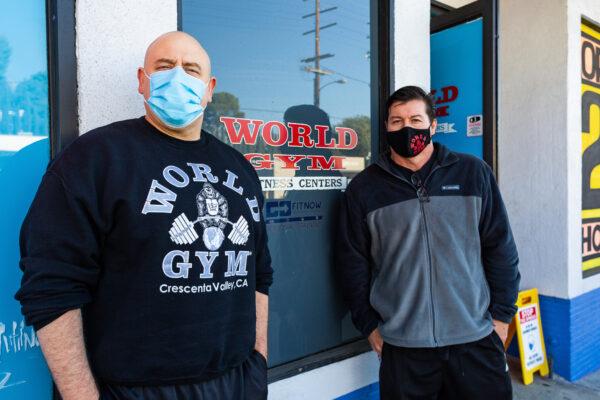 Owners Brian Prewitt (L) and Steve Cuevas stand outside the World Gym in Tujunga, Calif., on Jan. 5, 2021. (John Fredricks/The Epoch Times)