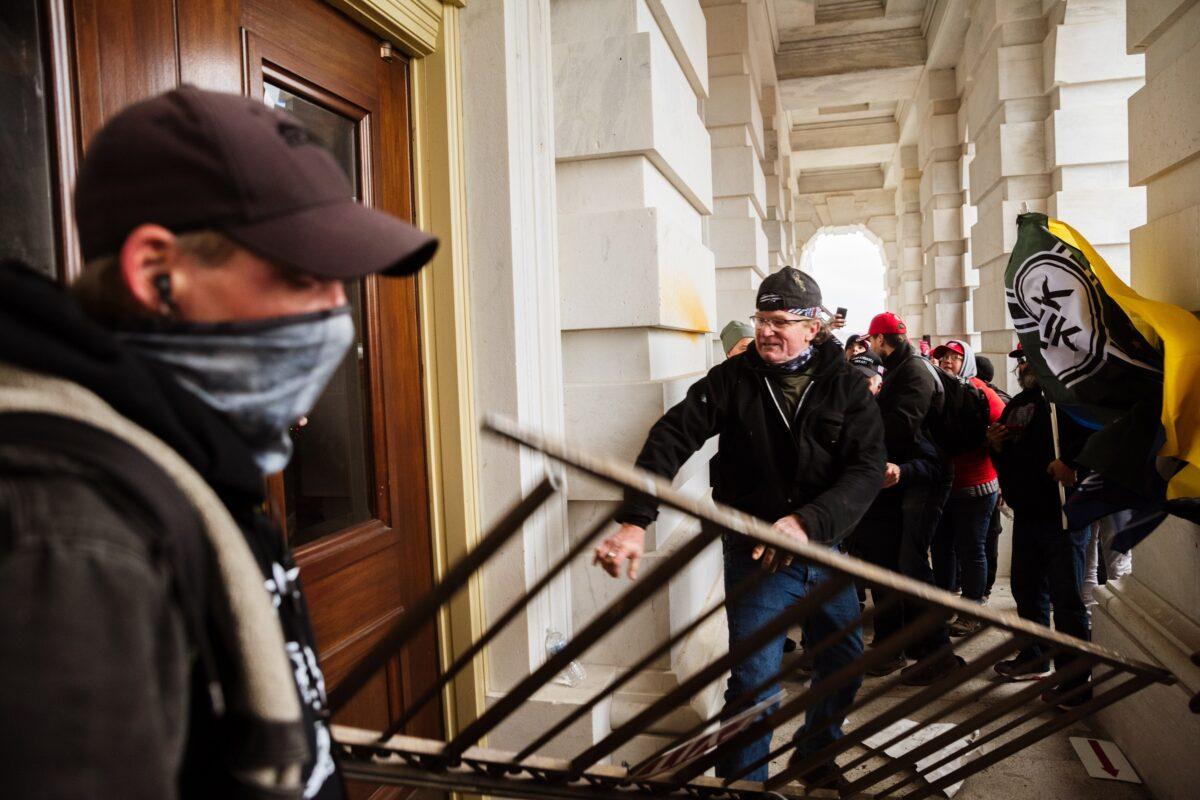 Protesters bash an entrance of the Capitol building in Washington on Jan. 6, 2021. (Jon Cherry/Getty Images)