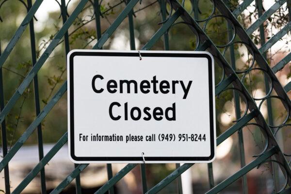 A sign hangs on a gate in front of a graveyard in Lake Forest, Calif., on Jan. 8, 2021. (John Fredricks/The Epoch Times)