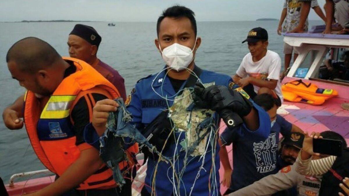 A member of the rescue team looking for an Indonesian plane that lost contact after taking off from the capital Jakarta holds suspected debris, at sea, on  Jan. 9, 2021. (Instagram @humasjakrire/via Reuters)