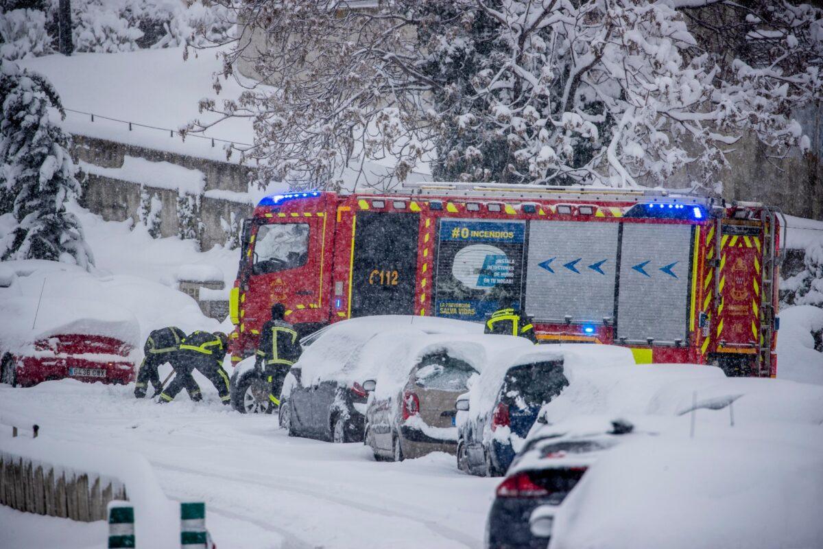 Firefighters work removing snow from a car during a heavy snowfall in Rivas Vaciamadrid, Spain, Saturday, Jan. 9, 2021. (Manu Fernandez/AP)
