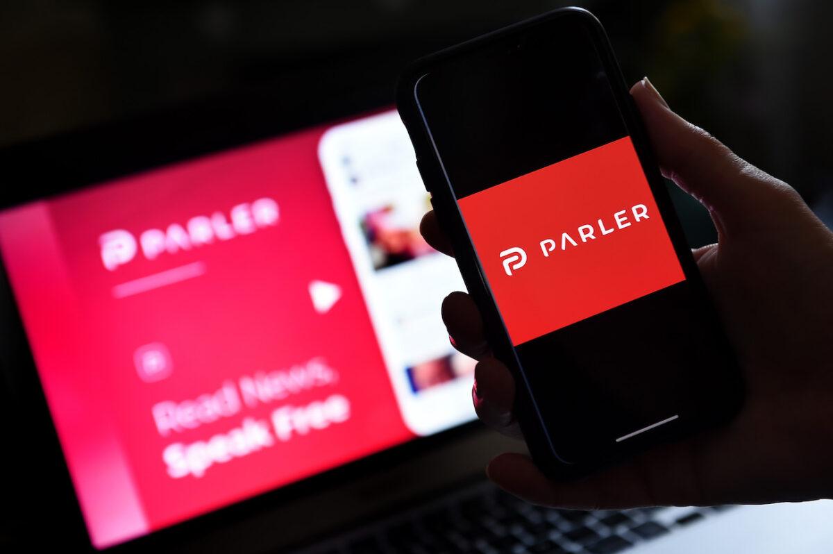 Social media application logo from Parler is displayed on a smartphone with its website in the background, in a file photo. (Olivier Douliery/AFP via Getty Images)