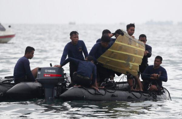 Indonesian Navy divers pull out a part of an airplane out of the water during a search operation for the Sriwijaya Air passenger jet that crashed into the sea near Jakarta, Indonesia, on Jan. 10, 2021. (Achmad Ibrahim/AP Photo)