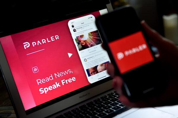 This illustration picture shows social media application logo from Parler displayed on a smartphone with its website in the background in Arlington, Va., on July 2, 2020. (Olivier Douliery/AFP via Getty Images)