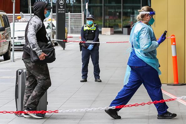 An international traveller is seen being escorted by hotel quarantine staff into a complex care Quarantine Hotel in Melbourne, Australia Dec. 7, 2020. (Asanka Ratnayake/Getty Images)