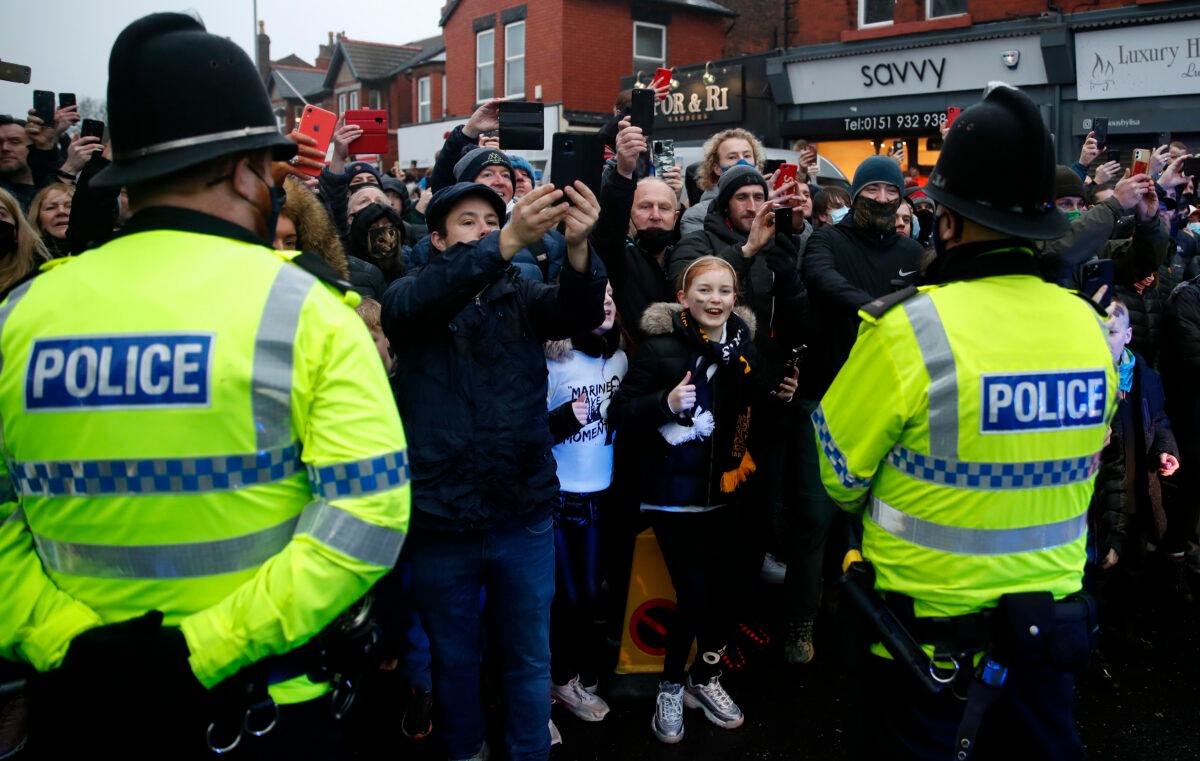 Police stand in front of fans who show their support outside the stadium prior to the FA Cup Third Round match between Marine and Tottenham Hotspur at Rossett Park in Crosby, England, on Jan. 10, 2021. (Clive Brunskill/Getty Images)