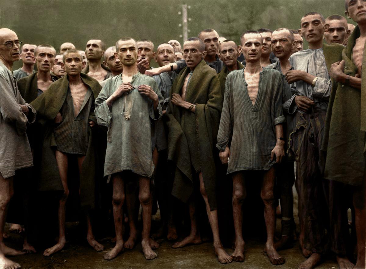 <a href="https://en.wikipedia.org/wiki/Ebensee_concentration_camp#/media/File:Ebensee_concentration_camp_prisoners_1945.jpg">National Archives and Records Administration</a>; © Colorized by Tom Marshall (<a href="http://www.photogra-fix.com/">PhotograFix</a>)