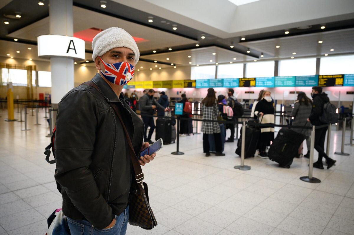 A passenger wearing a Union Flag face mask waits to board one of the few flights departing at Gatwick Airport in London, on Nov. 27, 2020. (Leon Neal/Getty Images)