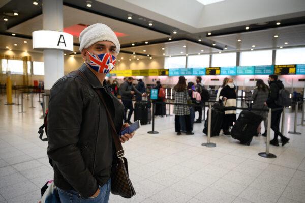 A passenger wearing a Union Flag face mask waits to board one of the few flights departing at Gatwick Airport in London on Nov. 27, 2020. (Leon Neal/Getty Images)