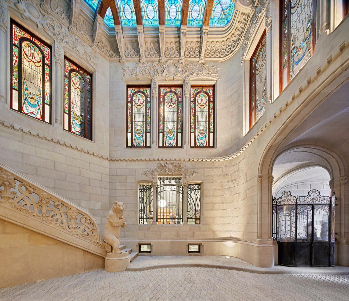 Surrounded by polychromed stained-glass windows, the lobby showcases Casa Burés’s prized art nouveau elements. In the center, an imposing life-size stone bear stands on its hind legs to protect the riches inside. (Jordi Folch and Jose Hevia)
