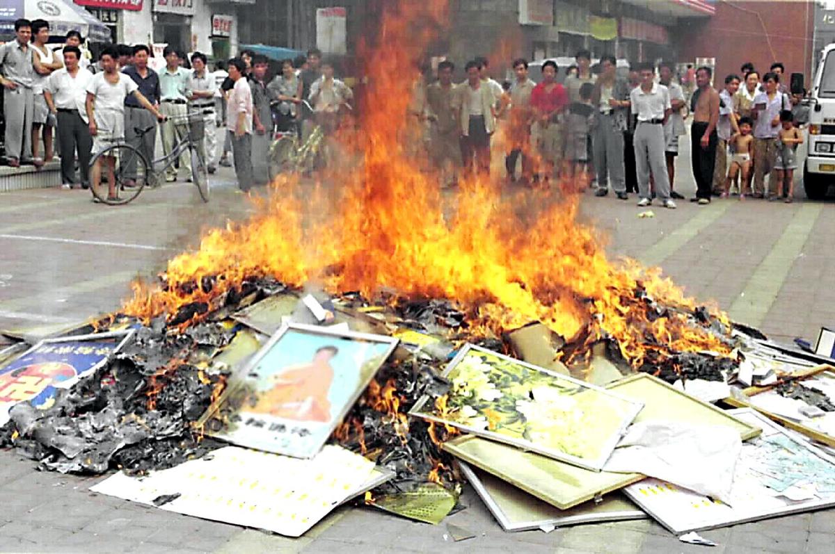 Falun Gong books are set on fire in Shouguang City, China's eastern Shandong Province, on Aug. 4, 1999. Chinese authorities in cities across China burned millions of Falun Gong books and materials after the communist regime launched a campaign to persecute the spiritual practice in July 1999. (STR/XINHUA/AFP via Getty Images)