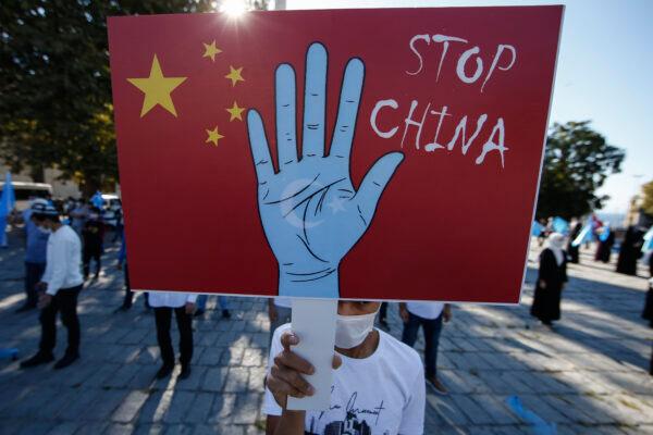 A protester from the Uyghur community living in Turkey holds an anti-China placard during a protest in Istanbul, on Oct. 1, 2020. (Emrah Gurel/AP Photo)