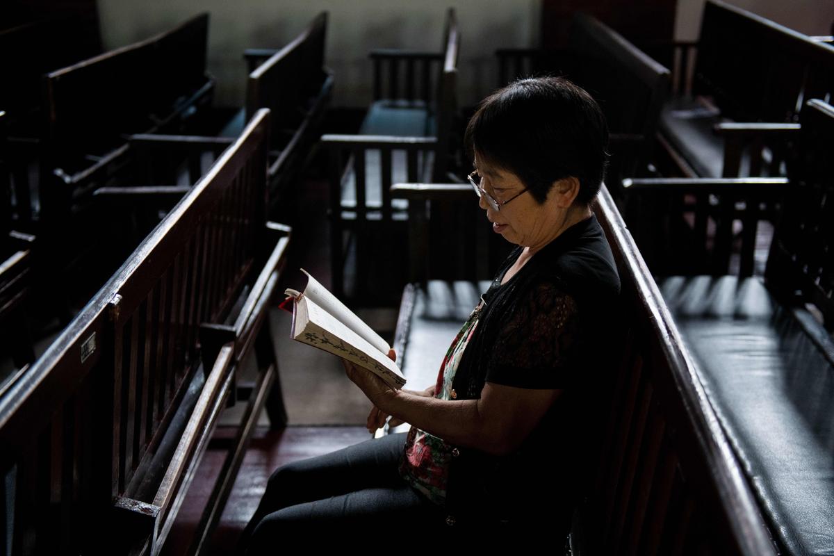 A woman reads the Bible at the Christian Glory church in Wuhan on Sept. 23, 2018. (NICOLAS ASFOURI/AFP via Getty Images)