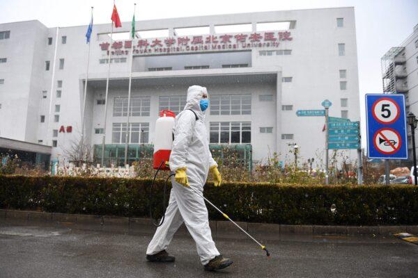 A worker sterilizes a path at the <span style="font-weight: 400;">You’an</span> Hospital in Beijing on Feb. 14, 2020. (GREG BAKER/AFP via Getty Images)