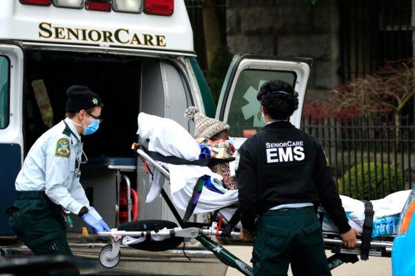 Emergency medical workers are seen unloading a patient outside a nursing home in Brooklyn, N.Y., on April 18, 2020. (Justin Heiman/Getty Images)
