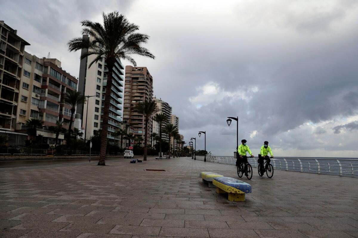 Police bike officers patrol on the empty waterfront promenade as the country starts a new lockdown, in Beirut, Lebanon, on Jan. 14, 2021. (Bilal Hussein/AP Photo)