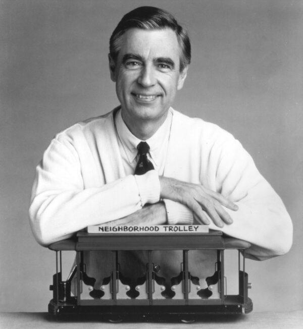Fred Rogers, the host of the children's television series, "Mr. Rogers' Neighborhood," rests his arms on a small trolley in this promotional portrait from the 1980's. (Family Communications Inc./Getty Images)