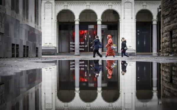 Pedestrians wearing masks walk through an empty downtown in Calgary on Dec. 9, 2020. (Jeff McIntosh/The Canadian Press)