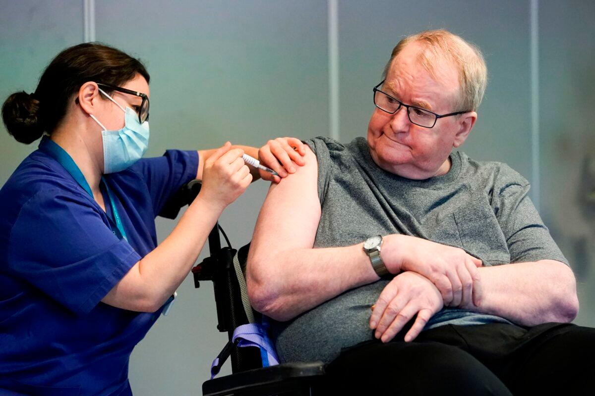 Svein Andersen, 67 years-old resident of 'Ellingsrud home' and first in Norway to receive the vaccine, is given the Pfizer-Biontech CCP vaccine by Nurse Maria Golding in Oslo, Norway, on Dec. 27, 2020. (Fredrik Hagen/NTB/AFP via Getty Images)