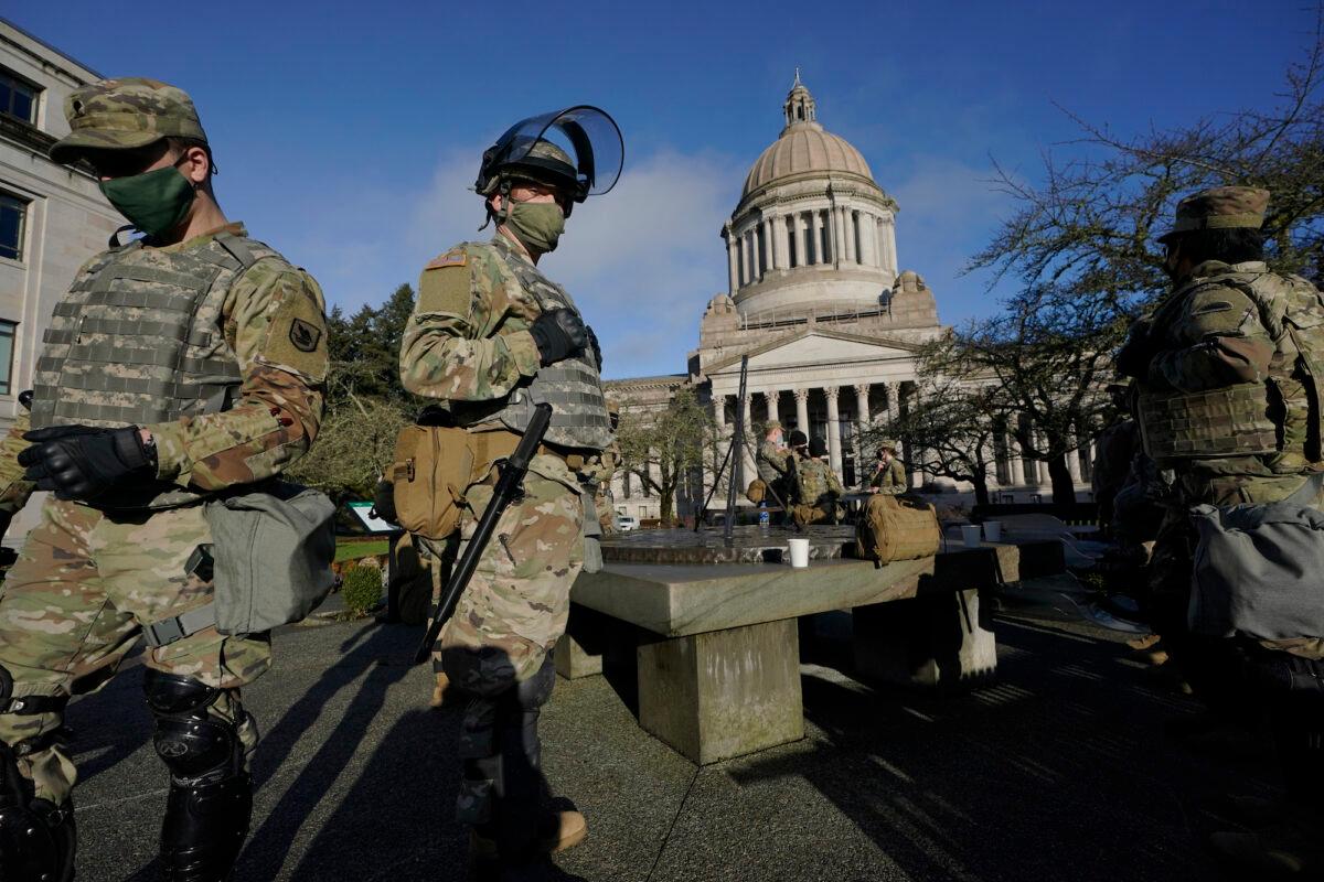Members of the Washington National Guard stand near the Legislative Building, in Washington, on Jan. 10, 2021. (Ted S. Warren/AP Photo)