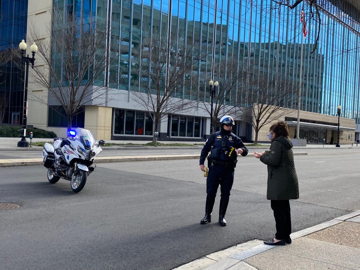A policeman gives directions to a pedestrian near the L’Enfant Plaza metro station in Washington on Jan. 17, 2021. (Terri Wu/The Epoch Times)