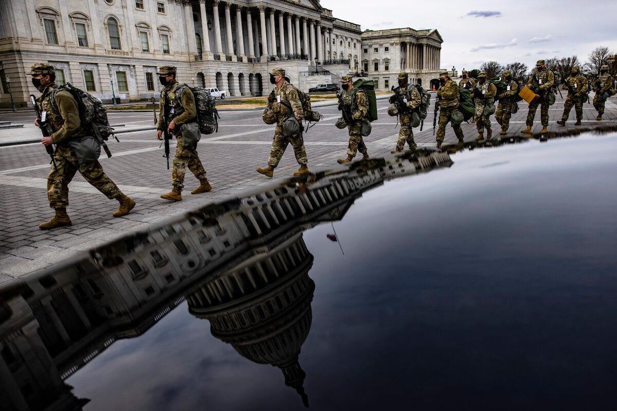 Virginia National Guard soldiers march across the east from of the U.S. Capitol on their way to their guard posts in Washington on Jan. 16, 2021. (Samuel Corum/Getty Images)