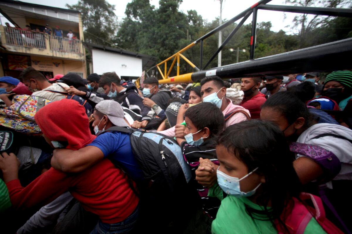 Honduran migrants hoping to reach the U.S. cross the border patrolled by Guatemalan soldiers, in El Florido, Guatemala, on Jan. 16, 2021. (Sandra Sebastian/AP Photo)