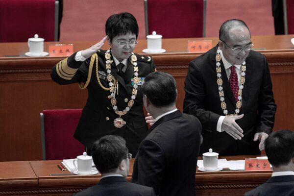 Chen Wei (L), a Chinese army general who led a team working on developing a COVID-19 vaccine, salutes after she received an award from Chinese leader Xi Jinping at the end of a ceremony to honor people who fought against the pandemic, at the Great Hall of the People in Beijing, China on Sept. 8, 2020. (NICOLAS ASFOURI/AFP via Getty Images)