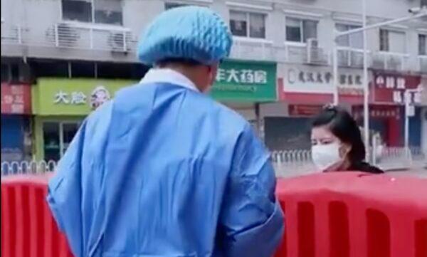 A nurse meets with a young woman whose mother died of COVID-19 in Wuhan, China, in early 2020. (Screenshot/YouTube)