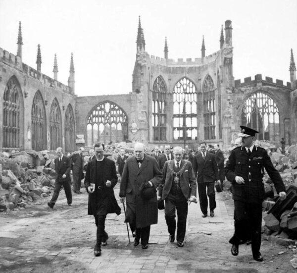 Winston Churchill walking through the ruined nave of Coventry Cathedral, England, after it was damaged in the Coventry Blitz in November 1940. (Public domain)