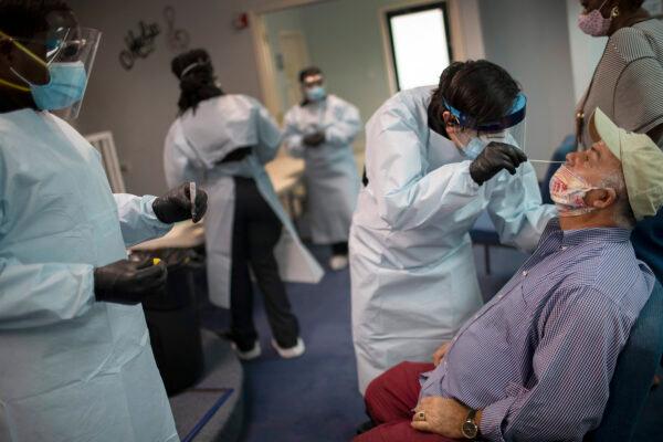 A health care worker use a nasal swab to test Marcelino Soto for COVID-19 at a pop up testing site at the Koinonia Worship Center and Village in Pembroke Park, Fla., on July 22, 2020. (Joe Raedle/Getty Images)