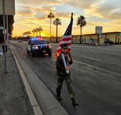 Jordan Ramirez carries an American  flag on his weekly walk between police stations in Southern California on Dec. 5, 2020. (Courtesy of Dimas Ramirez)