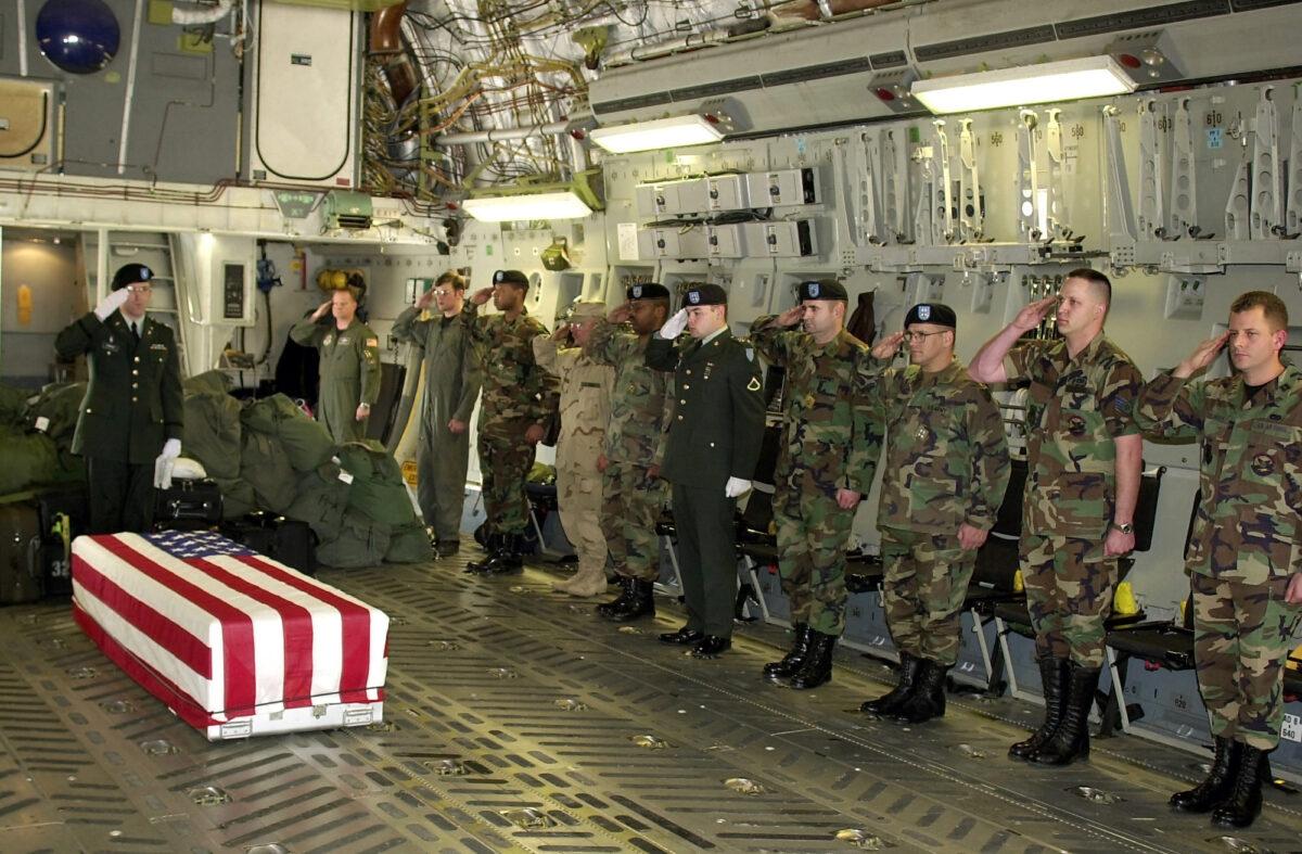 U.S. military personnel salute a flag-draped coffin bearing the remains of U.S. Navy Seal Chief Hospital Corpsman Matthew J. Bourgeois onboard an aircraft at Karshi-Khanabad Air Base, Uzbekistan, in this photo released April 28, 2005. (U.S. Department of Defense/National Security Archive via Getty Images)