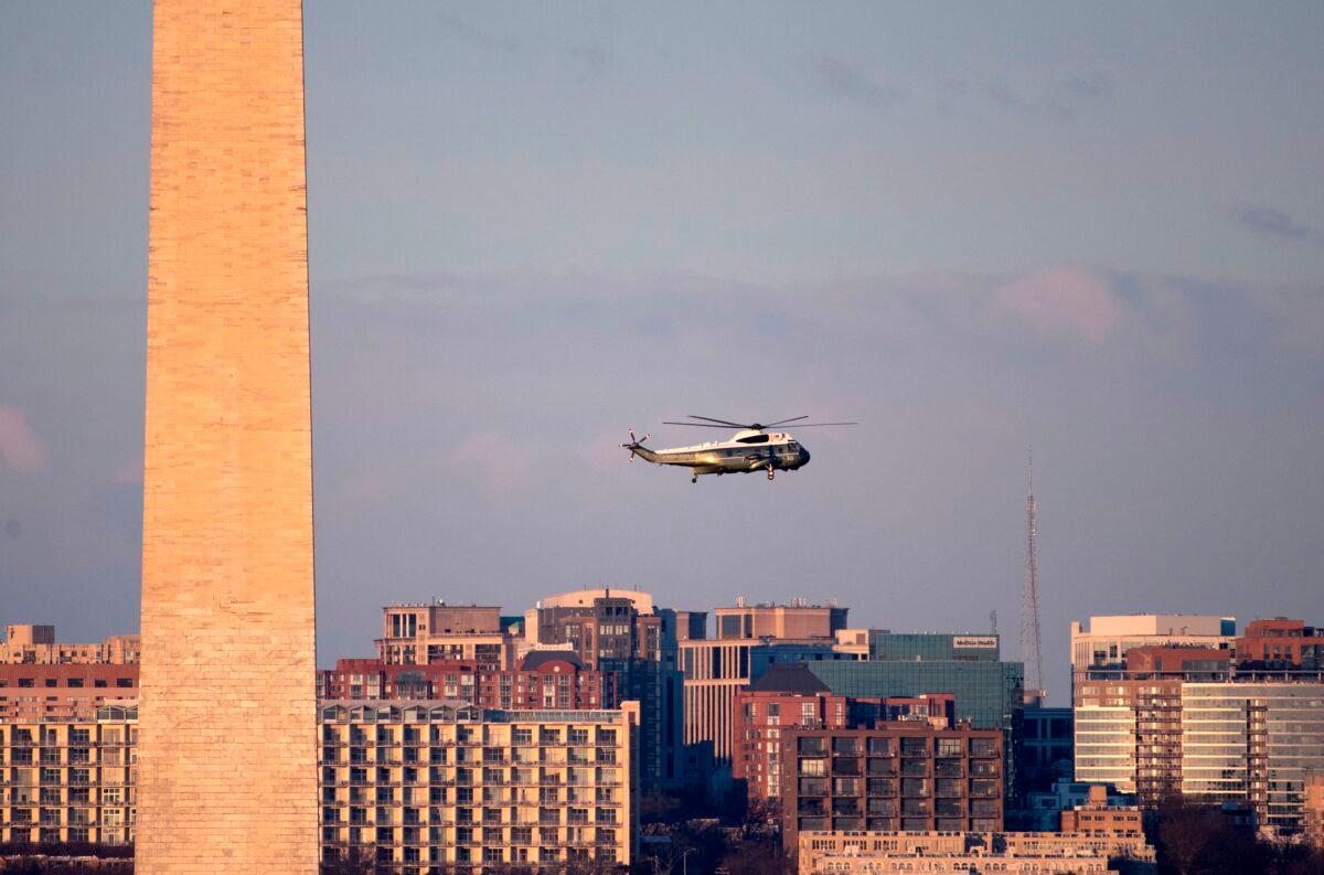 Marine One flies by the Washington Monument (L) on its way to the White House on Jan. 20, 2021. (Caroline Brehman/Pool/AFP via Getty Images)