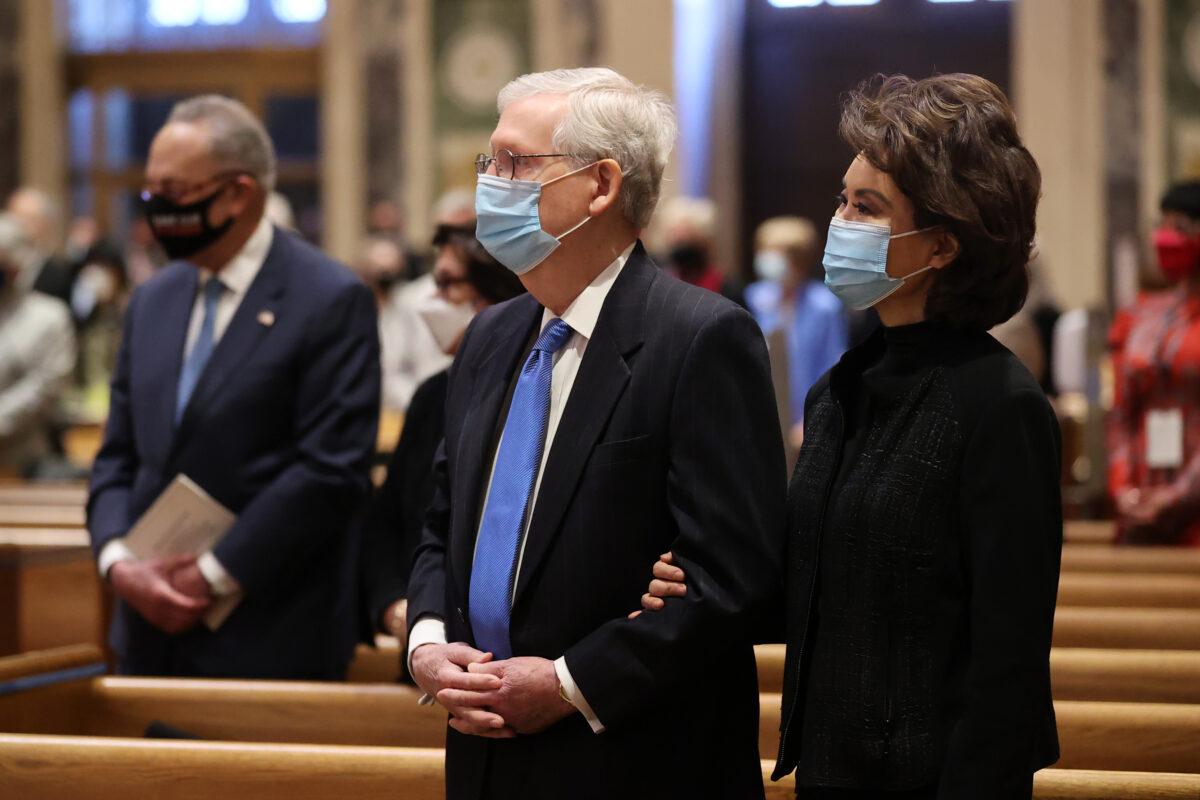 Senate Majority Leader Mitch McConnell (R-Ky.), left, and his wife, Elaine Chao, along with Senate Minority Leader Chuck Schumer (D-N.Y.), in the background, attend services at the Cathedral of St. Matthew the Apostle in Washington on Jan. 20, 2021. (Chip Somodevilla/Getty Images)