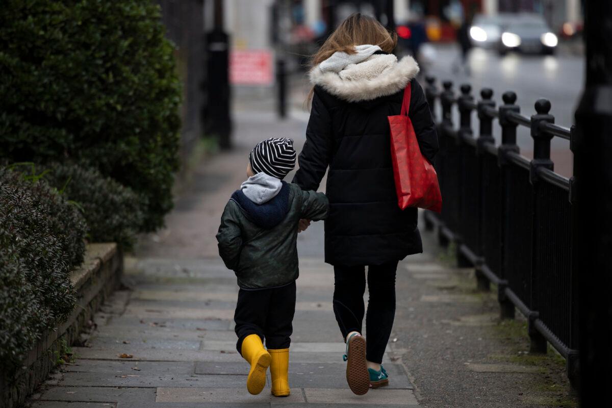 A child and parent walk near a closed primary school in Deptford, London, on Jan. 4, 2021. (Dan Kitwood/Getty Images)